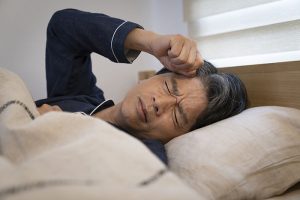 寝苦しそうな壮年の男性