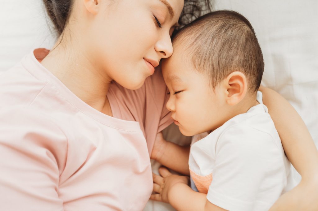 幼児と眠る母親