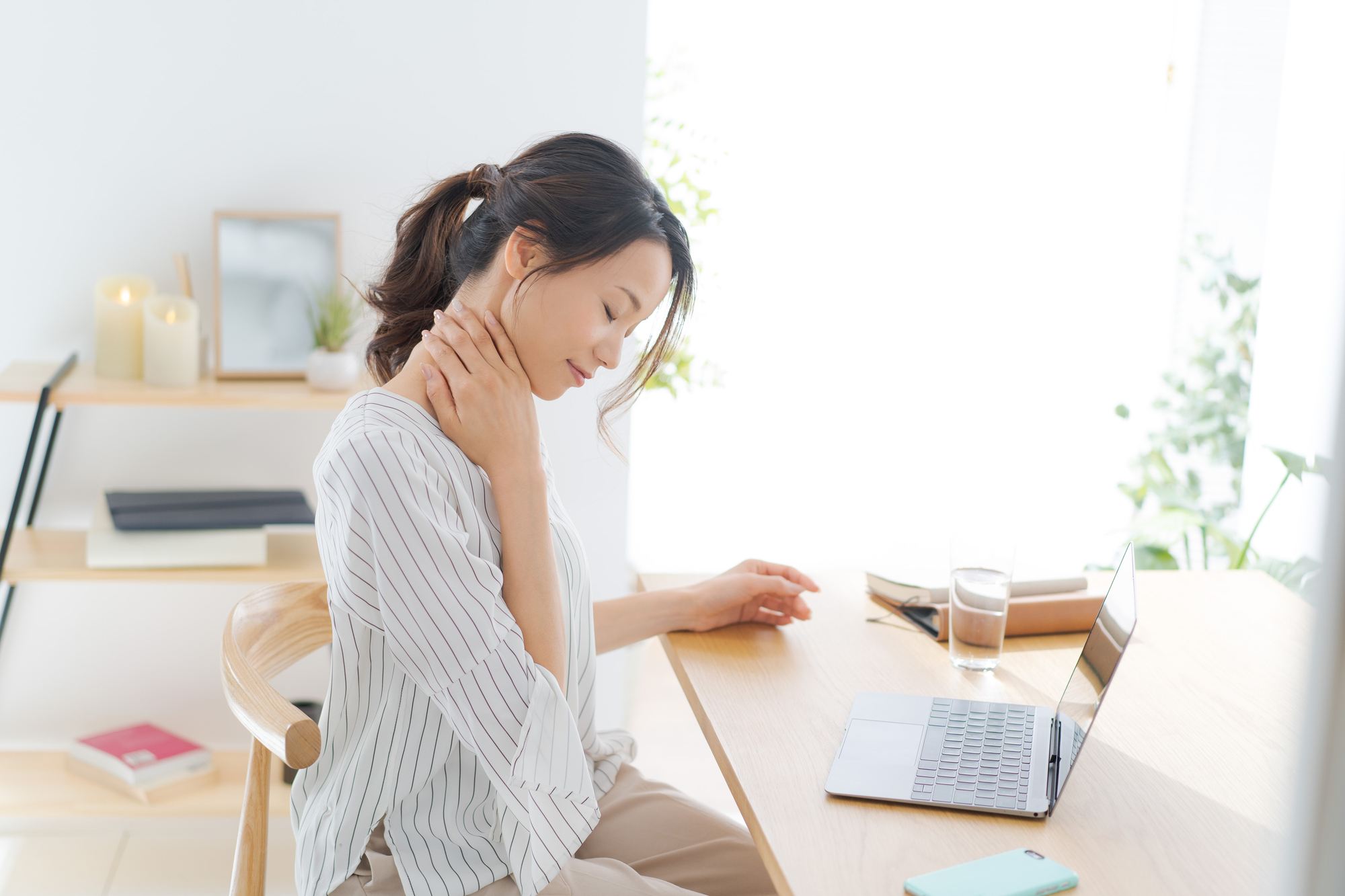 在宅ワーク中に首を痛める女性