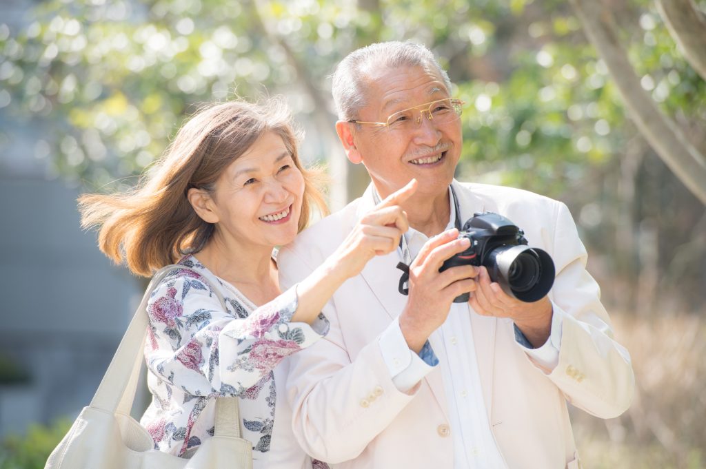 シニア夫婦が旅行でカメラ撮影をする様子