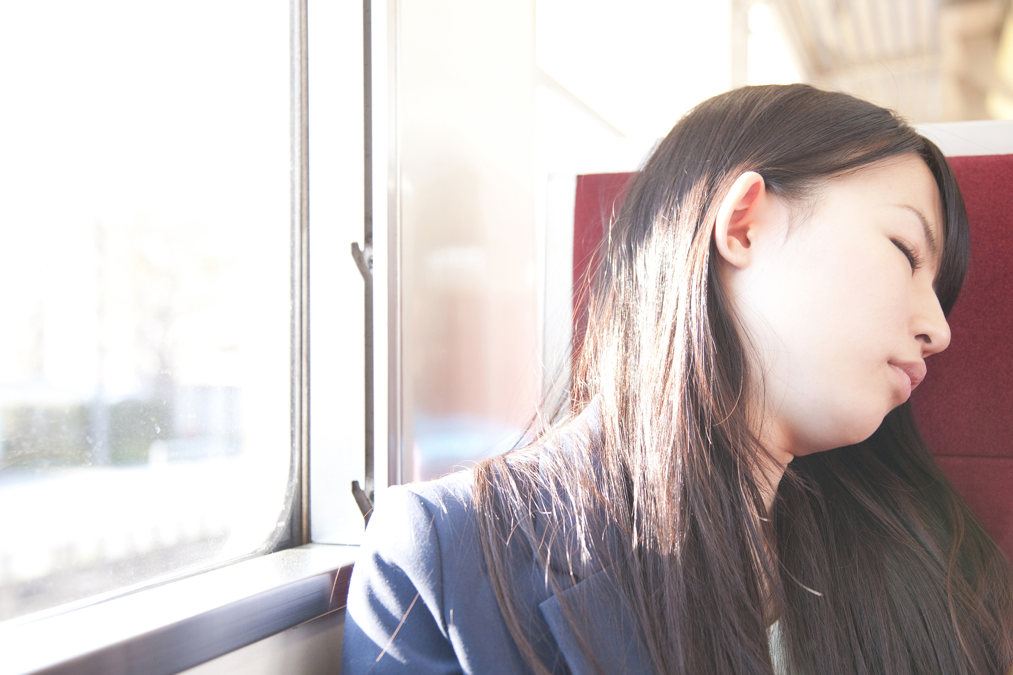 電車で居眠りをしている女学生