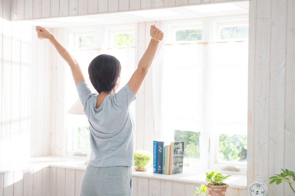 起床する女性の後ろ姿