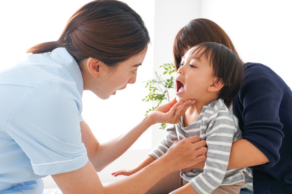 子供の口腔内を診る歯科医