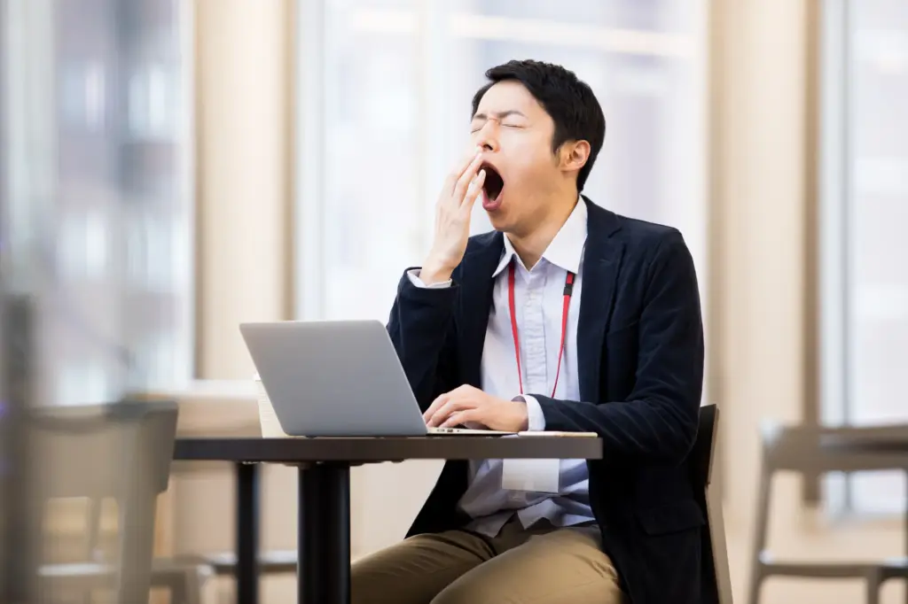 仕事中眠そうにする男性