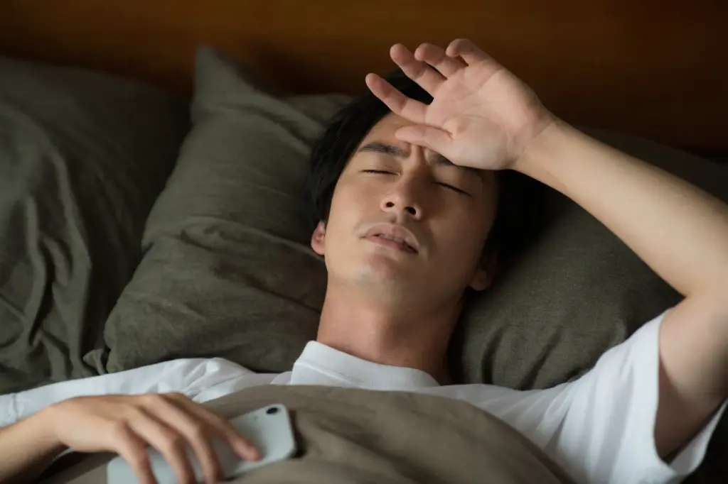 寝苦しそうにする男性