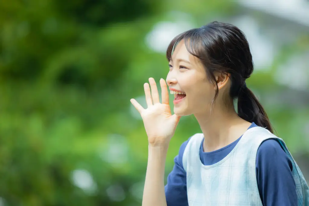 笑顔で誰かを呼ぶ女性